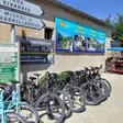 Base Eyrieux Sport aux Ollières-sur-Eyrieux — vélos alignés devant la boutique, rosalie et kayak, au départ de la Dolce Via