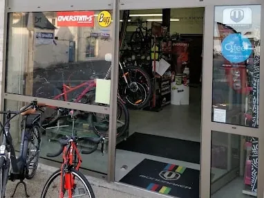 Magasin La Tête Dans Le Guidon à Jonzac — vitrine ouverte, vélos électriques et VTT garés devant l’entrée