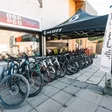 Magasin Prieur-Blanc Sports à Embrun — VTT électriques et gravels alignés devant la vitrine, sous une tonnelle